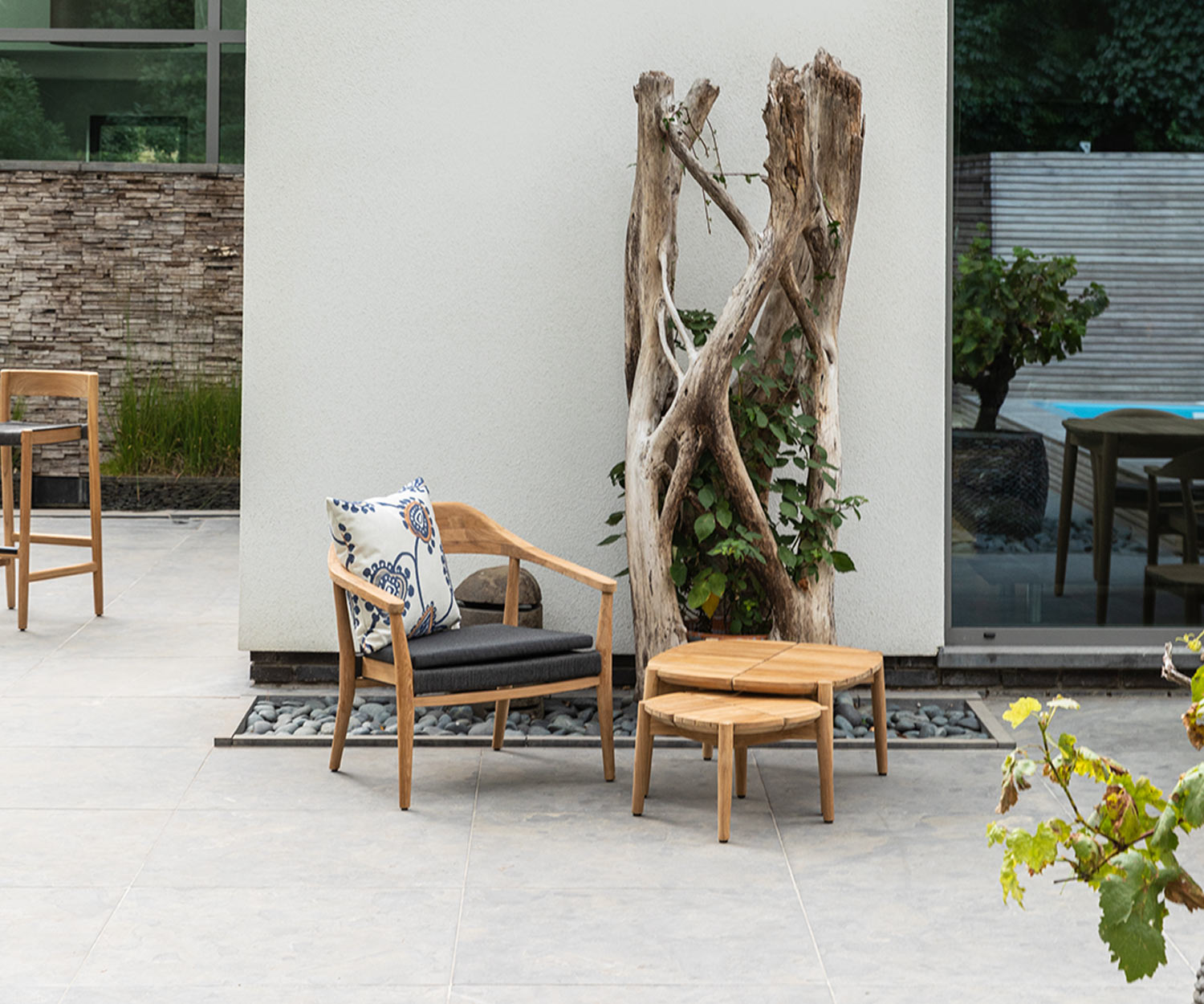 Lounge moderne Oasiq Copenhagen avec tables d'appoint sur une terrasse à côté d'un arbre